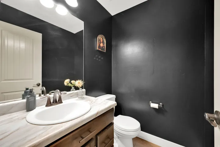 Vanity with an oval undermount sink, bronze-finish faucet, and a stone-look countertop