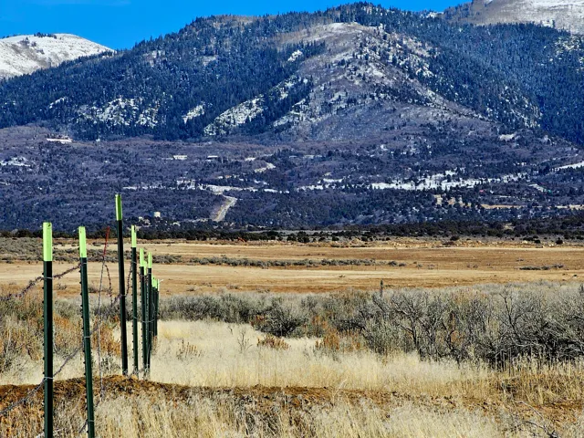 Expansive undeveloped land with a distant mountain backdrop and a barbed wire fence