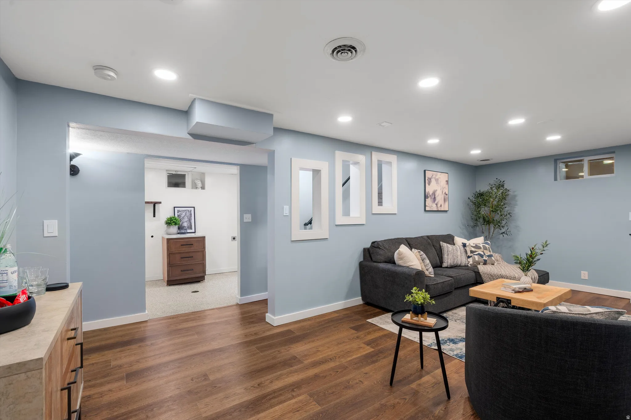 Recessed lighting illuminates the wood-finish flooring