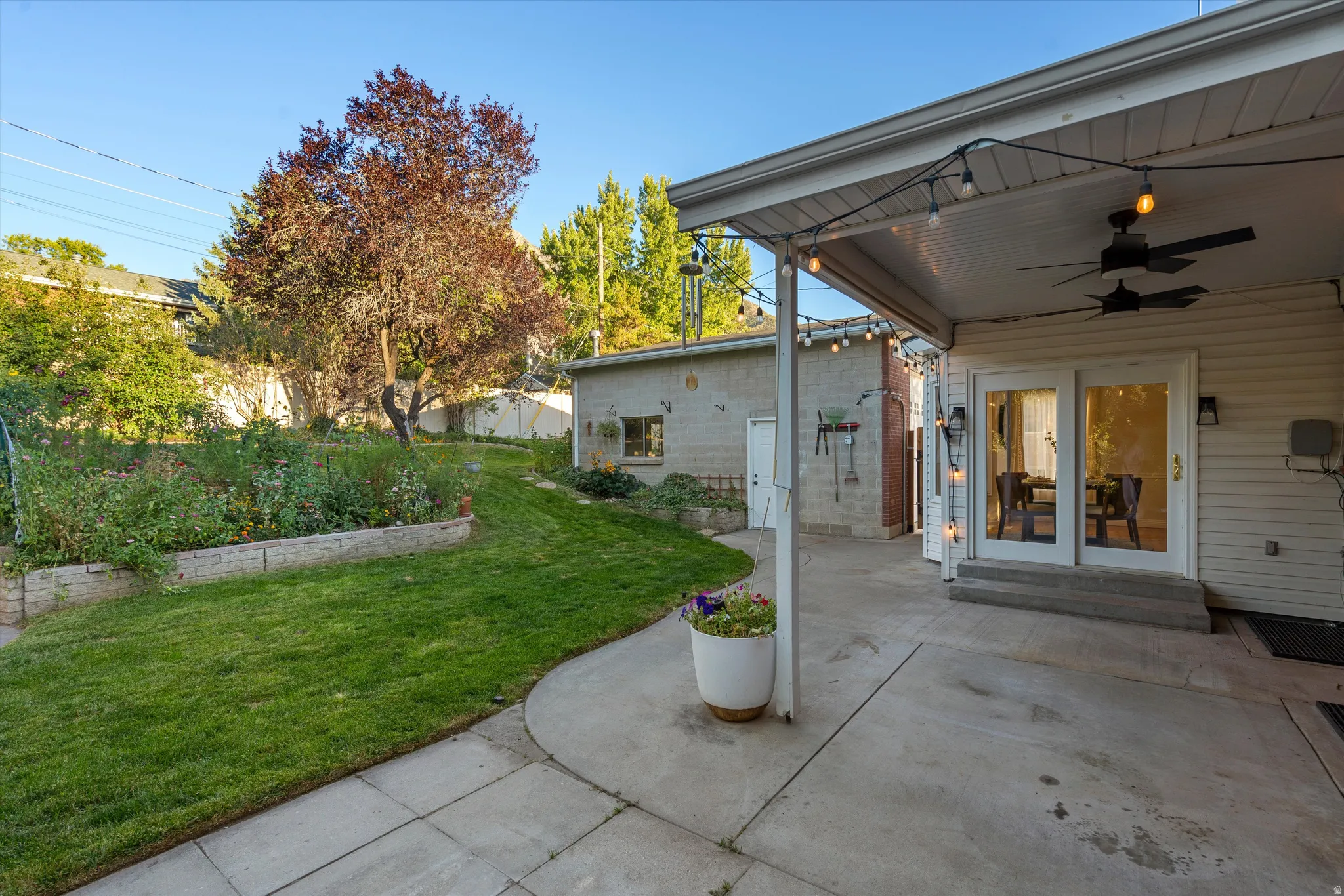 Covered patio with integrated ceiling fans and string lighting