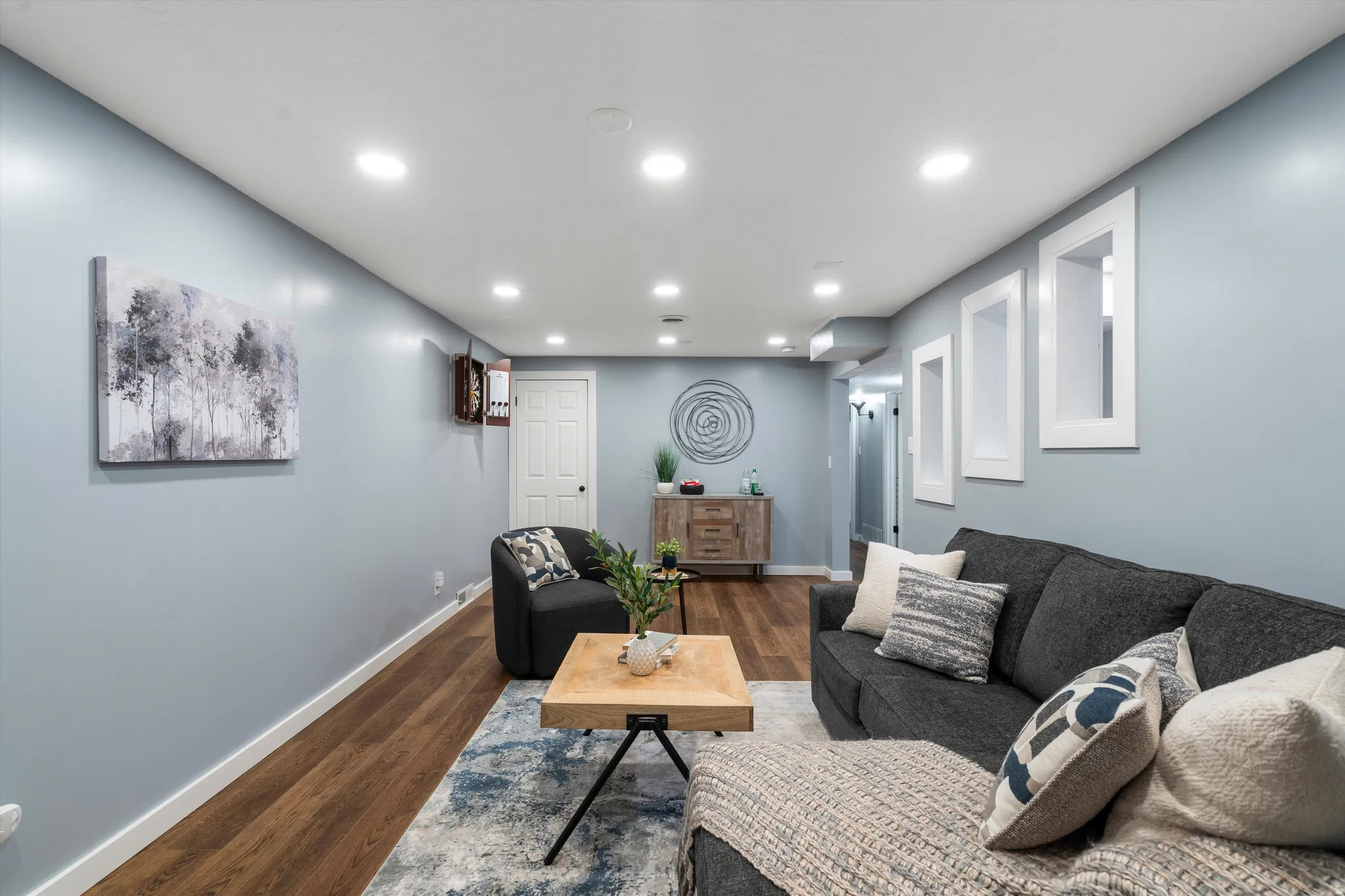 Recessed lighting, wood-finish flooring, white trim, and built-in wall niches