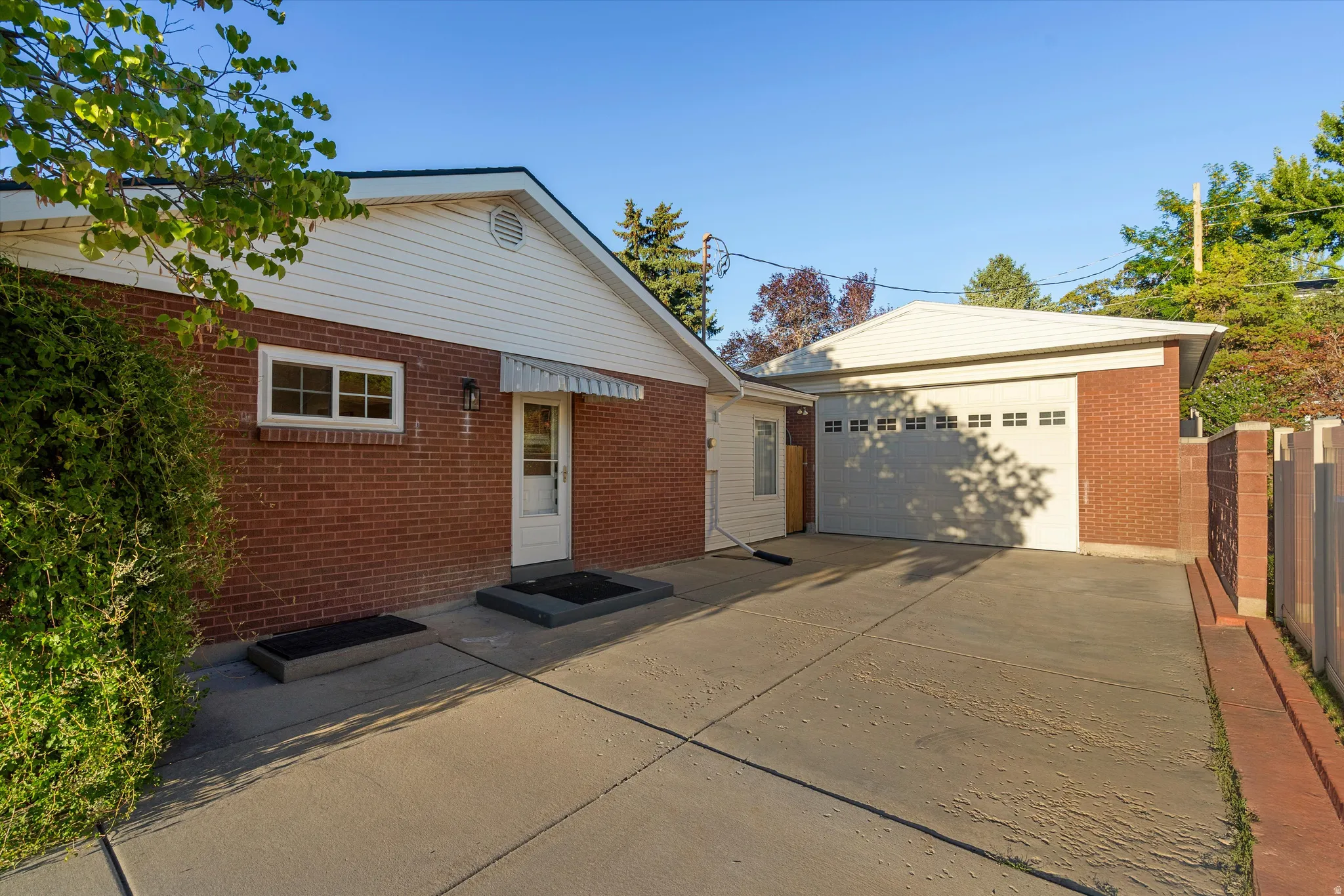 Brick exterior with white siding accents and detached garage.