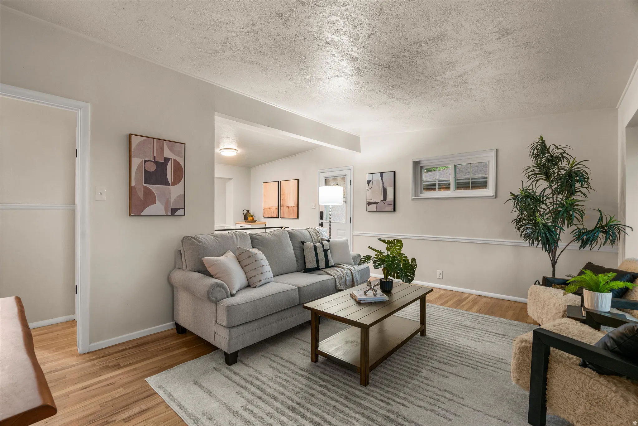 Hardwood flooring, light-colored walls, crown molding, and large windows