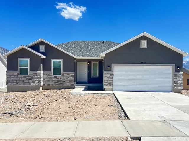 Contemporary exterior with dark gray stucco and light gray stone veneer accents