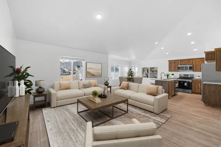 Vaulted ceilings with recessed lighting, large windows, wood-finish flooring, and a kitchen featuring stainless steel appliances and wood cabinetry
