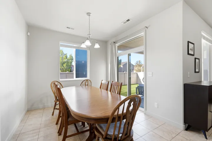 Tiled flooring, overhead light fixture, single window, sliding glass door, and backyard access