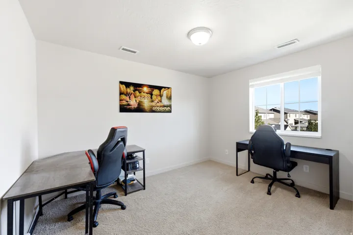 Carpeted room featuring a window with white trim, white walls, and a ceiling-mounted light fixture