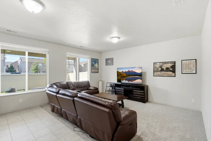 Expansive living area featuring light-colored walls and recessed lighting