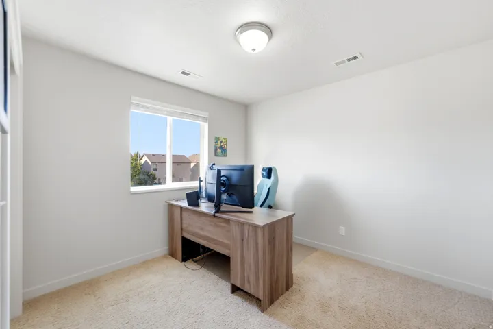 Neutral wall color, carpet flooring, window with white trim, and ceiling-mounted light fixture