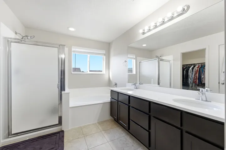 Double vanity with undermount sinks, wide mirror, and vanity lighting