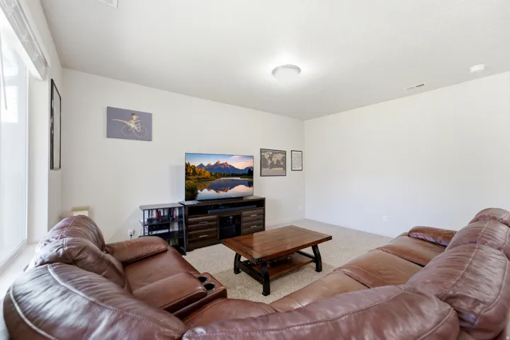 Recessed lighting, light-colored carpeting, large window, and wall-mounted light fixture
