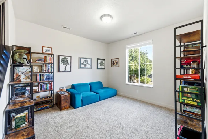 Carpeted flooring, white walls, recessed ceiling light, and a window with white trim