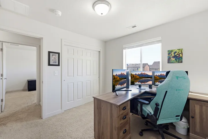 Natural light through a large window, neutral carpeting, and a closet with bifold doors