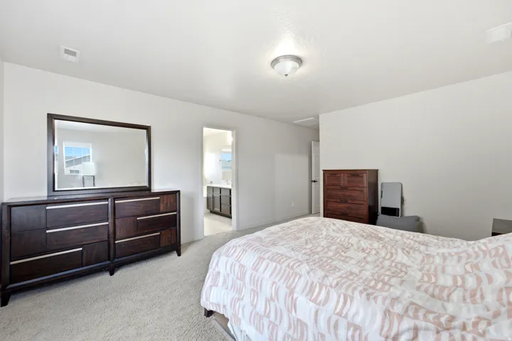 Recessed lighting, light-colored carpeting, and a doorway leading to an additional space with built-in cabinetry