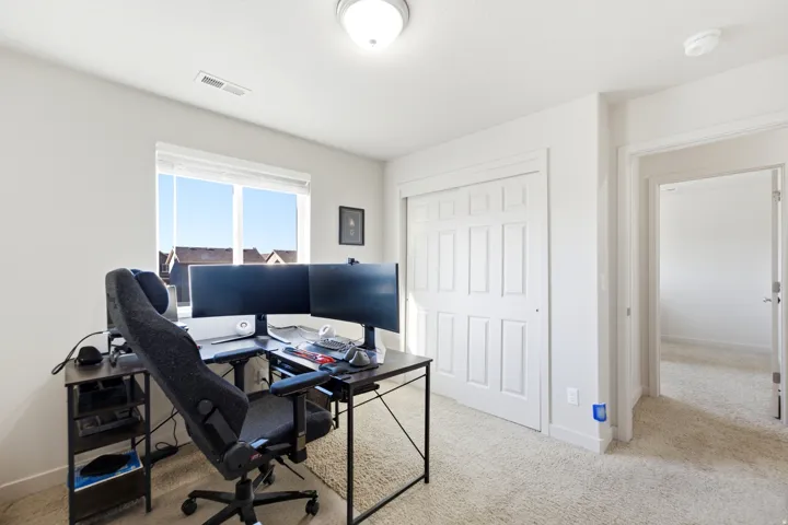 Recessed lighting, carpet flooring, a window with horizontal blinds, and a built-in closet with bifold doors