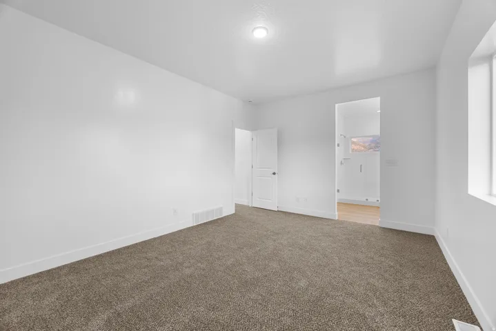 Plush carpet flooring, neutral paint palette, recessed lighting, and a window with natural light