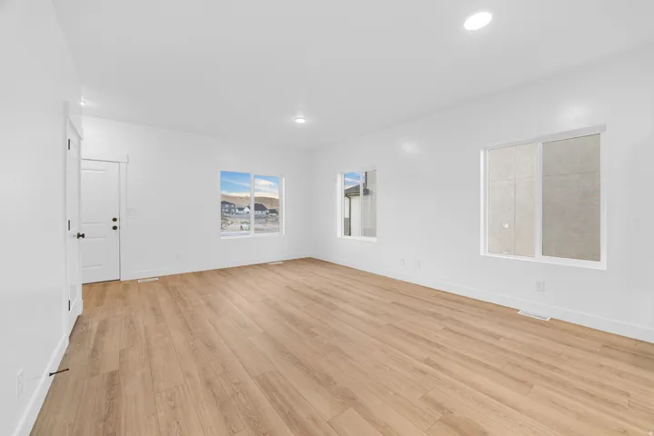 Bright interior featuring recessed ceiling lights, white walls, and light wood-finish flooring