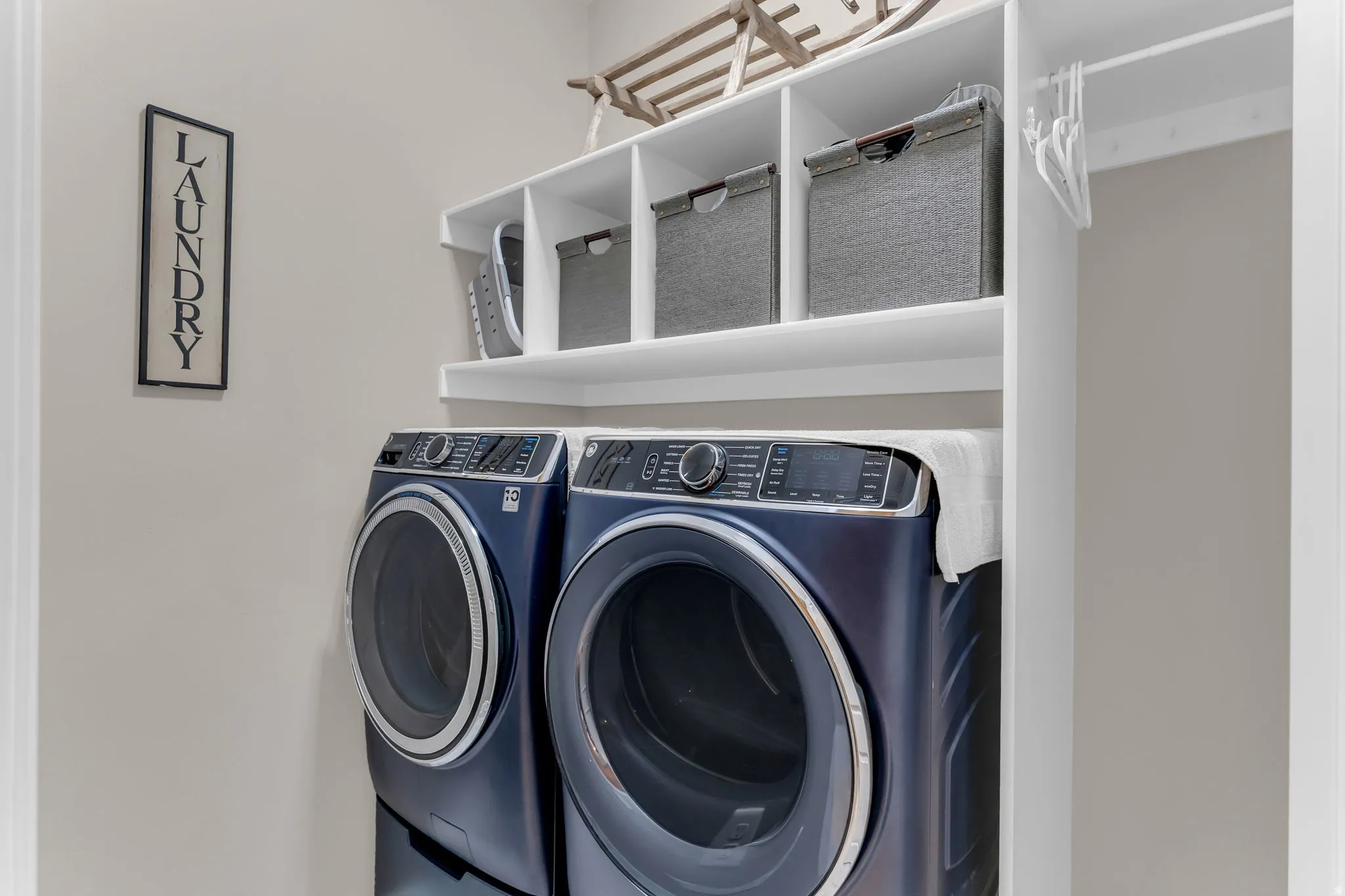 Built-in white shelving, integrated clothing rod, and neutral wall color