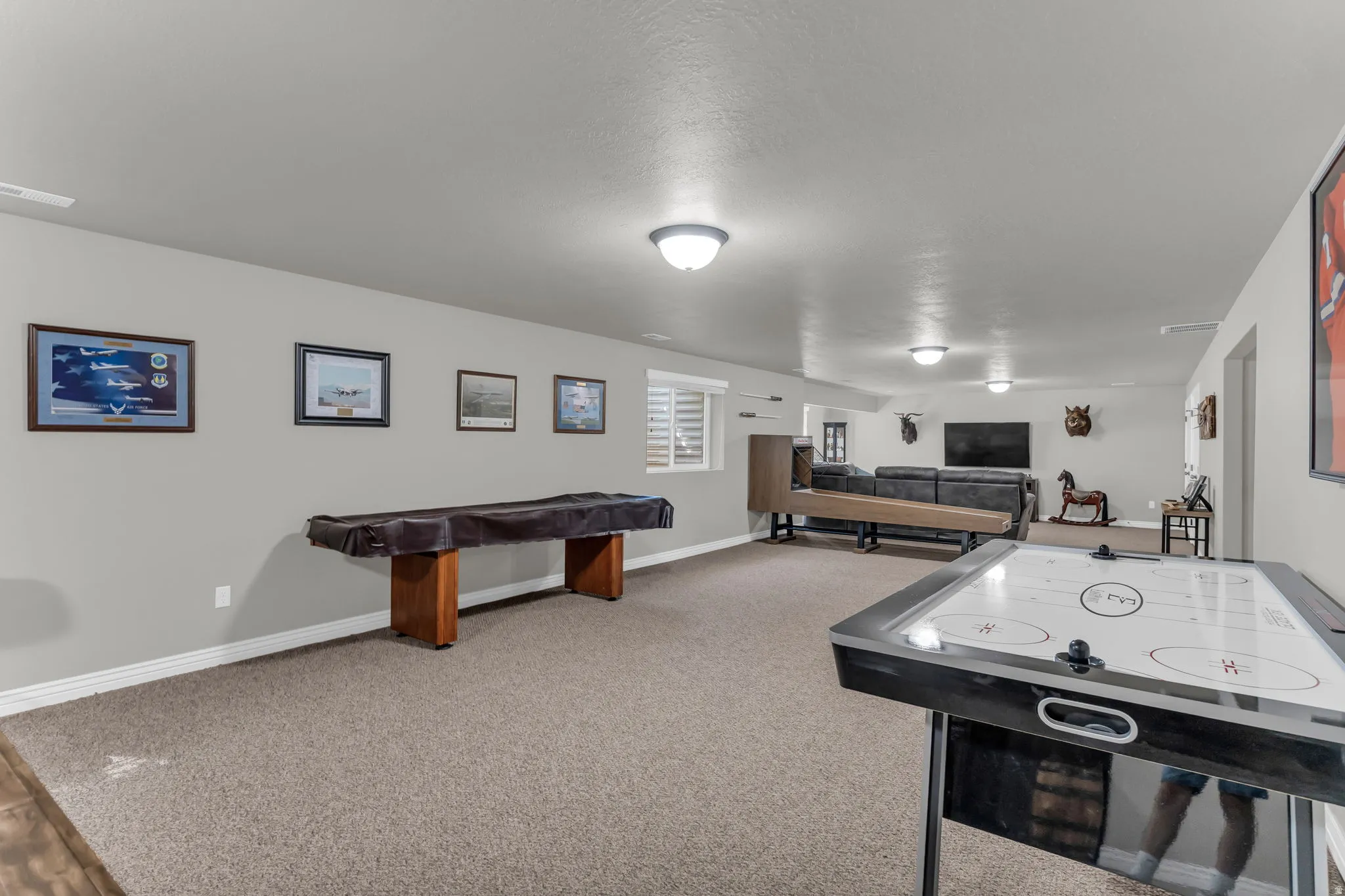 Expansive finished lower level featuring recessed lighting, light gray wall paint, and gray carpet flooring