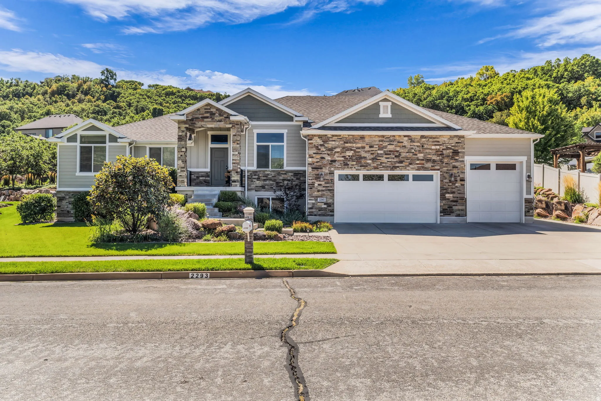 Stone and siding exterior with an attached three-car garage