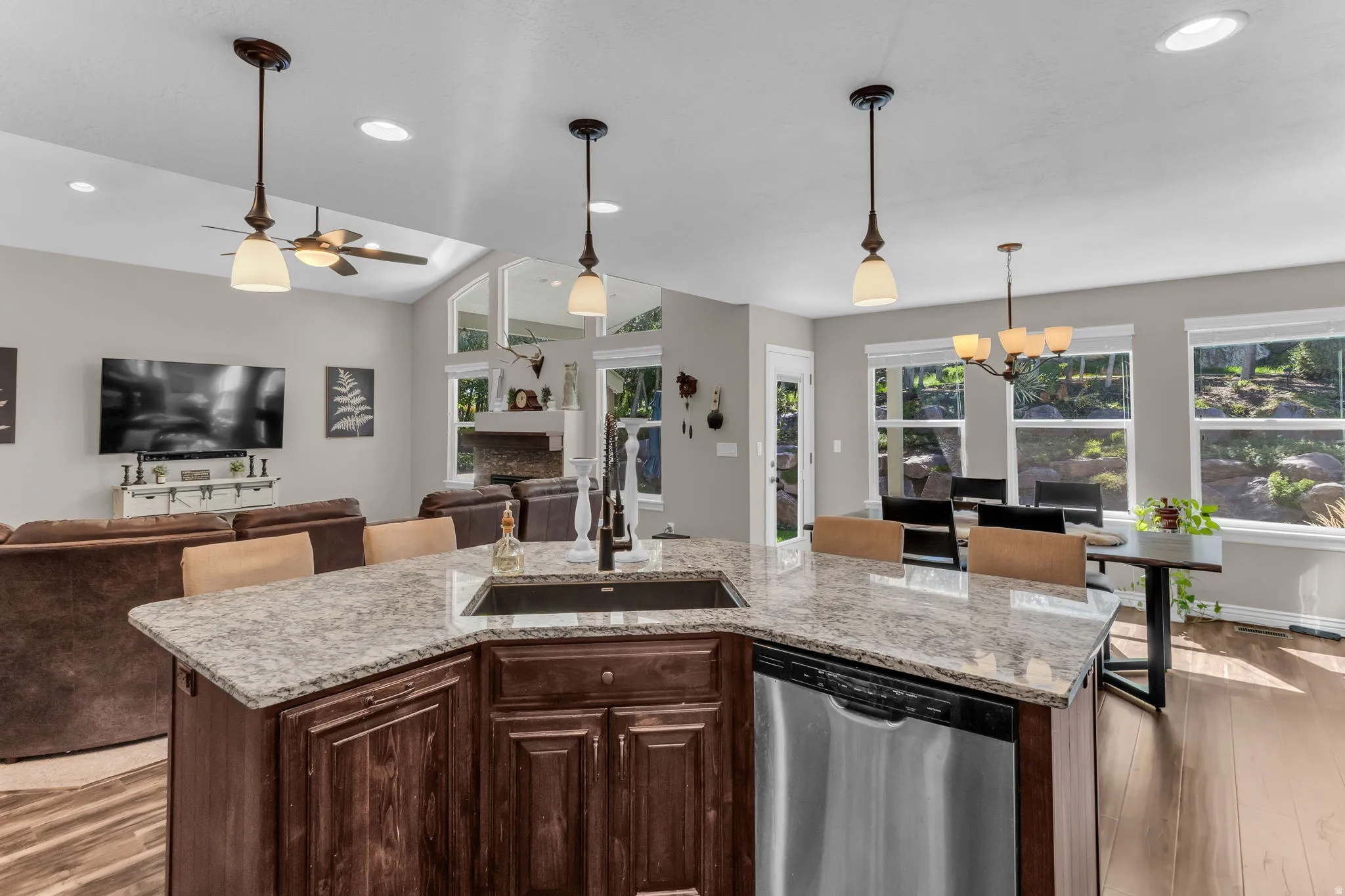 Kitchen island with a built-in sink, stainless steel dishwasher, and breakfast bar seating