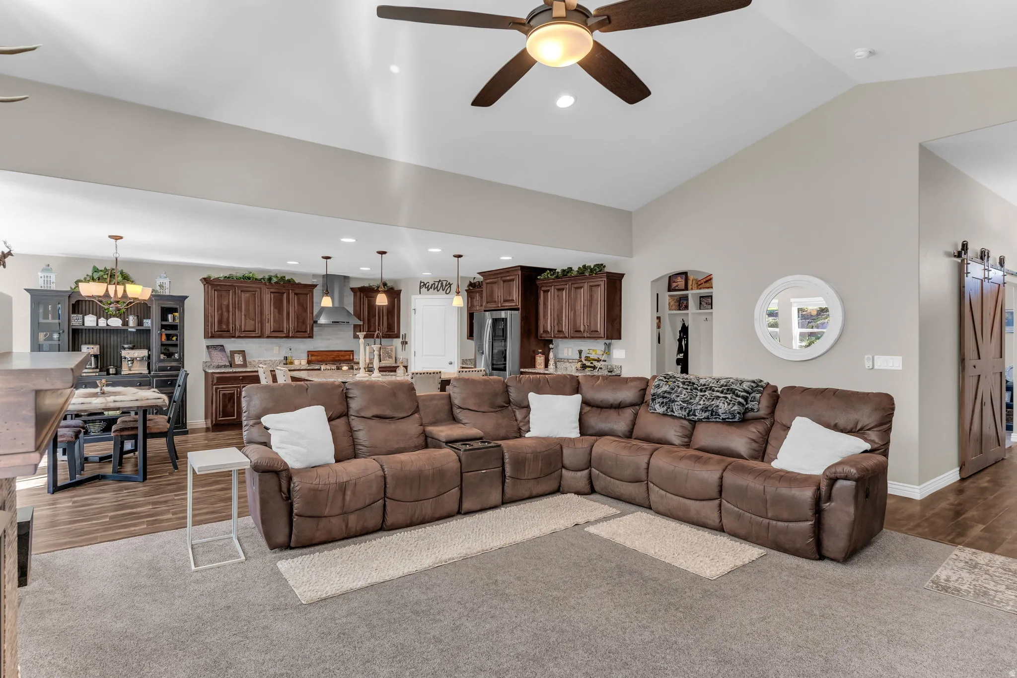 Vaulted ceiling with an overhead fan, recessed lighting, and wood-finish flooring