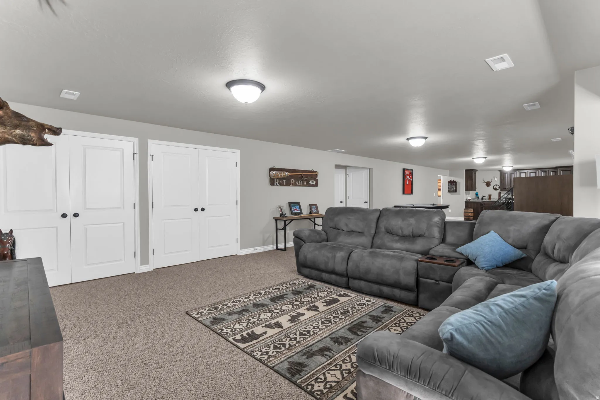Recessed lighting illuminates the carpeted flooring and white paneled doors
