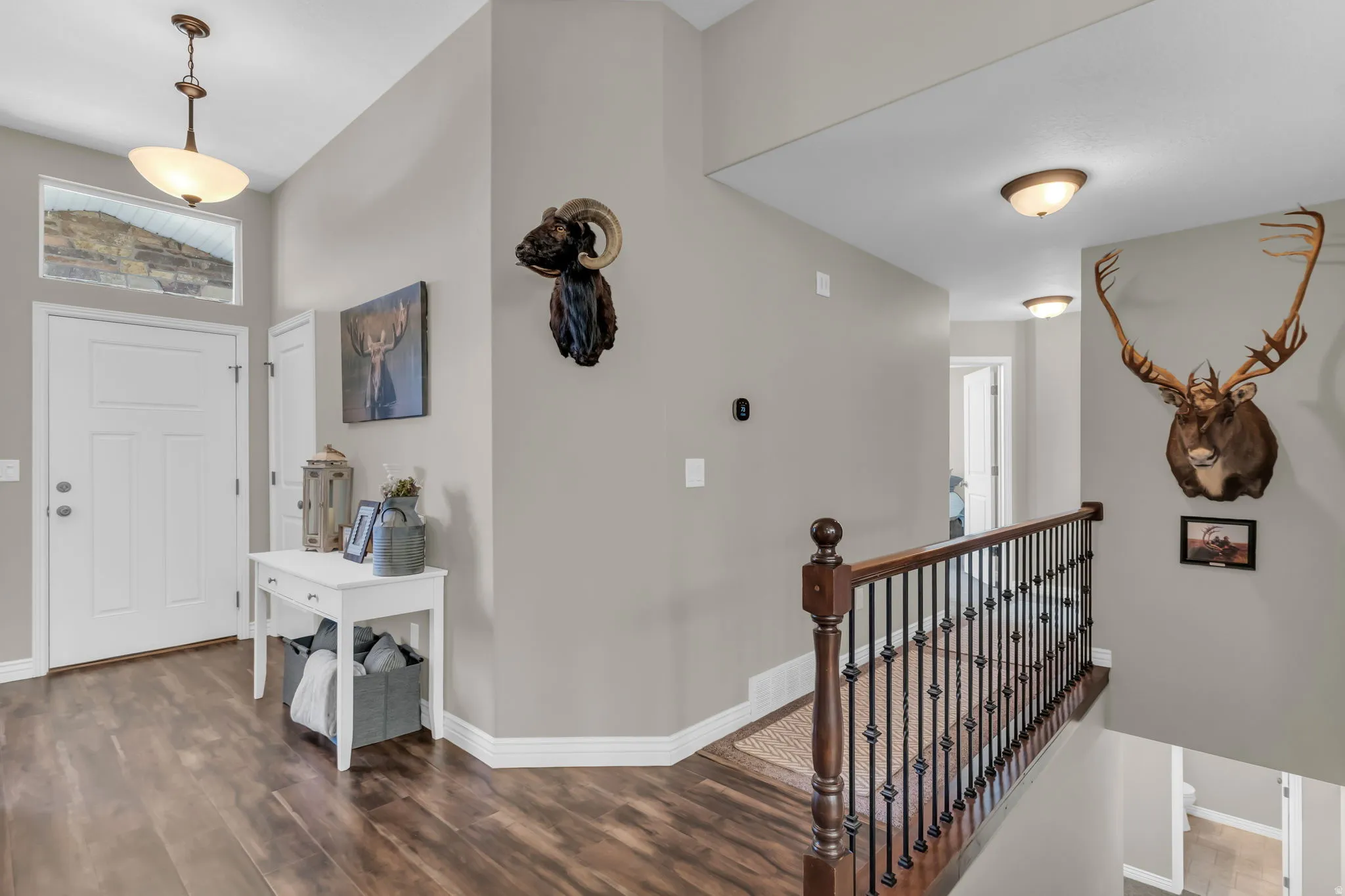 Entryway featuring wood-finish flooring, a white paneled door, and a transom window