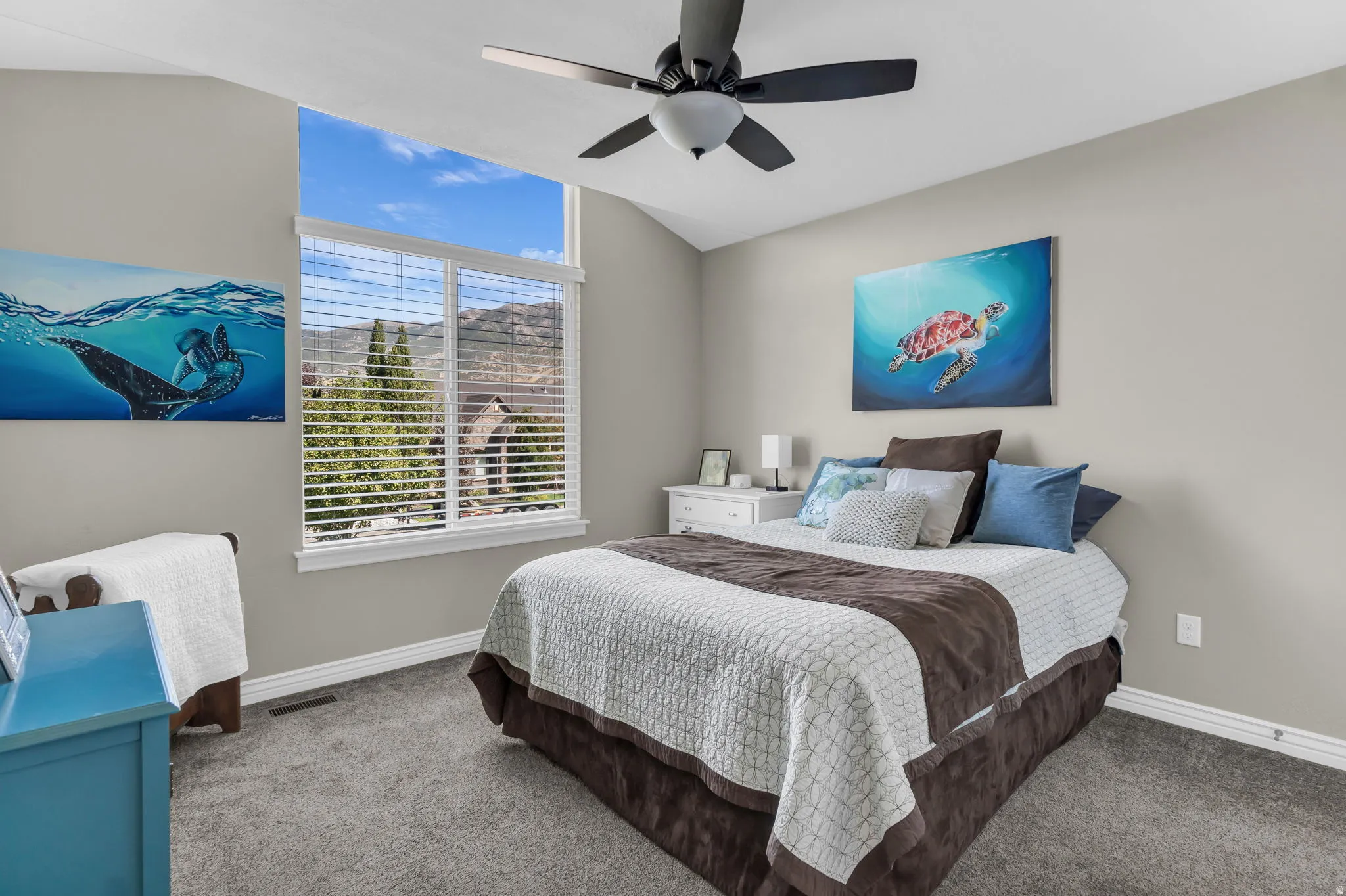 Room with sloped ceilings, ceiling fan, and carpeted flooring