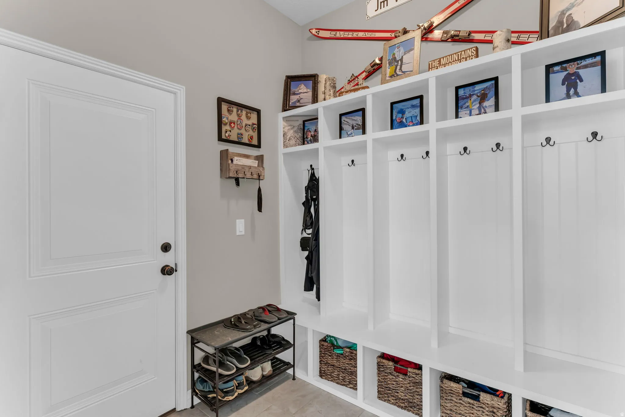 Built-in white storage lockers with coat hooks and integrated shelving