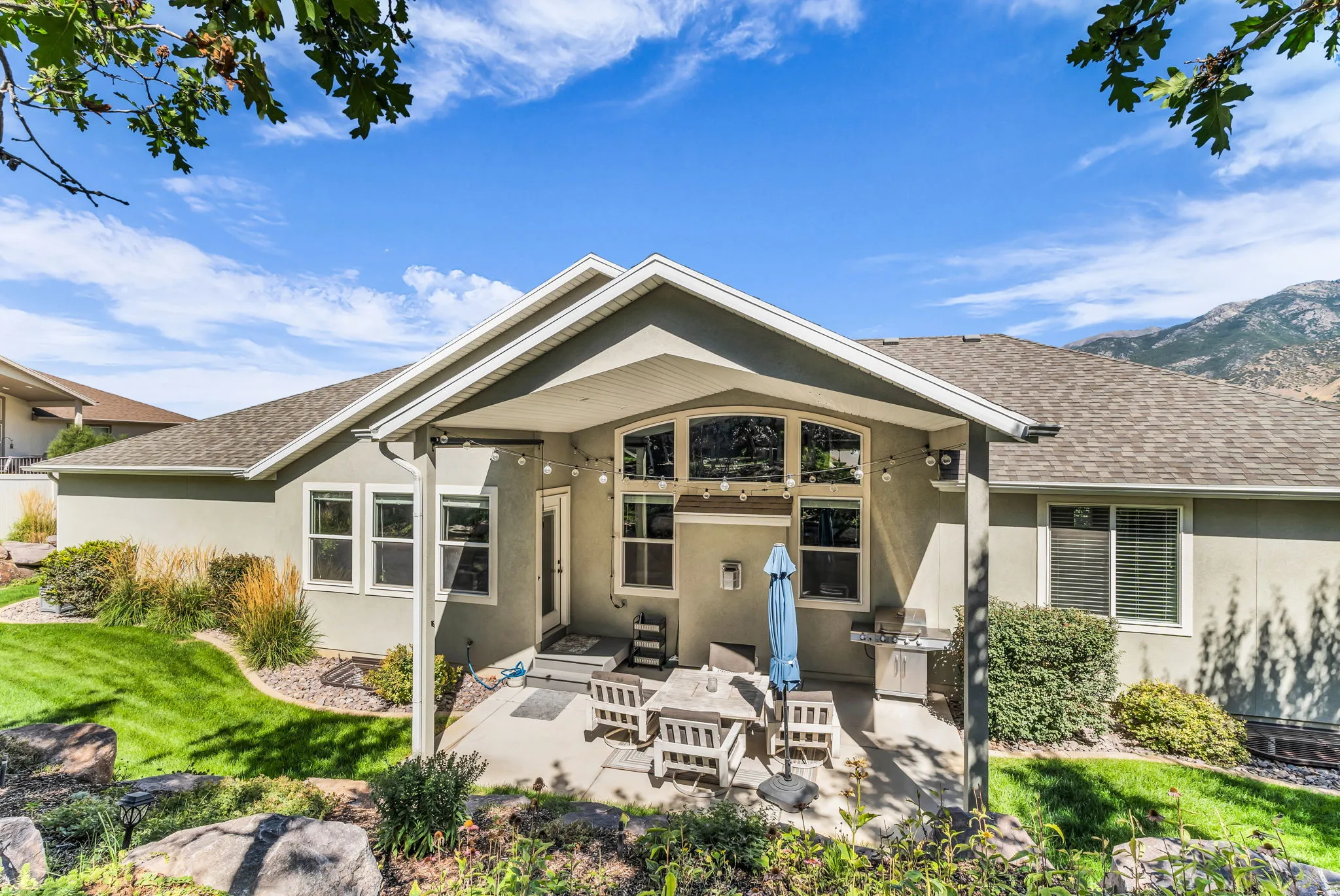 Covered patio with a concrete slab, a built-in outdoor grill, and a stucco exterior