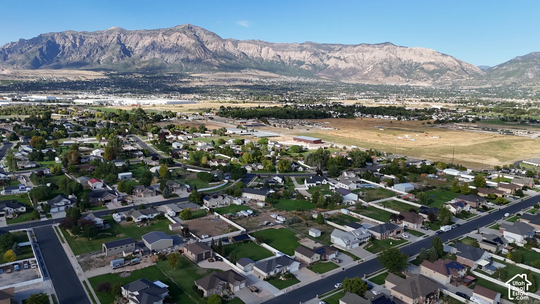 Neighborhood setting with residential properties, paved streets, and a mountainous backdrop