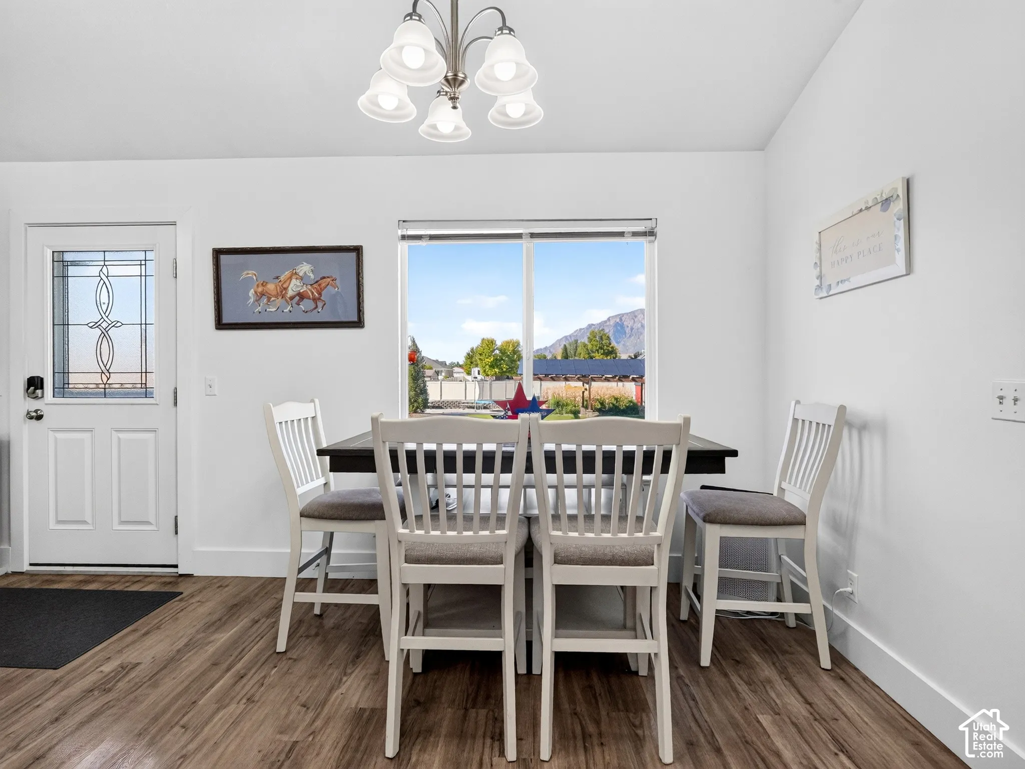 Wood-finish flooring, white walls, and a window with a mountain backdrop
