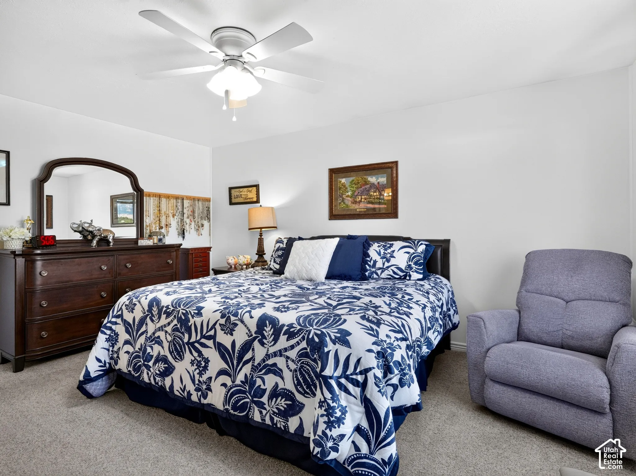 Ceiling fan with integrated lighting, neutral wall paint, and gray carpeting