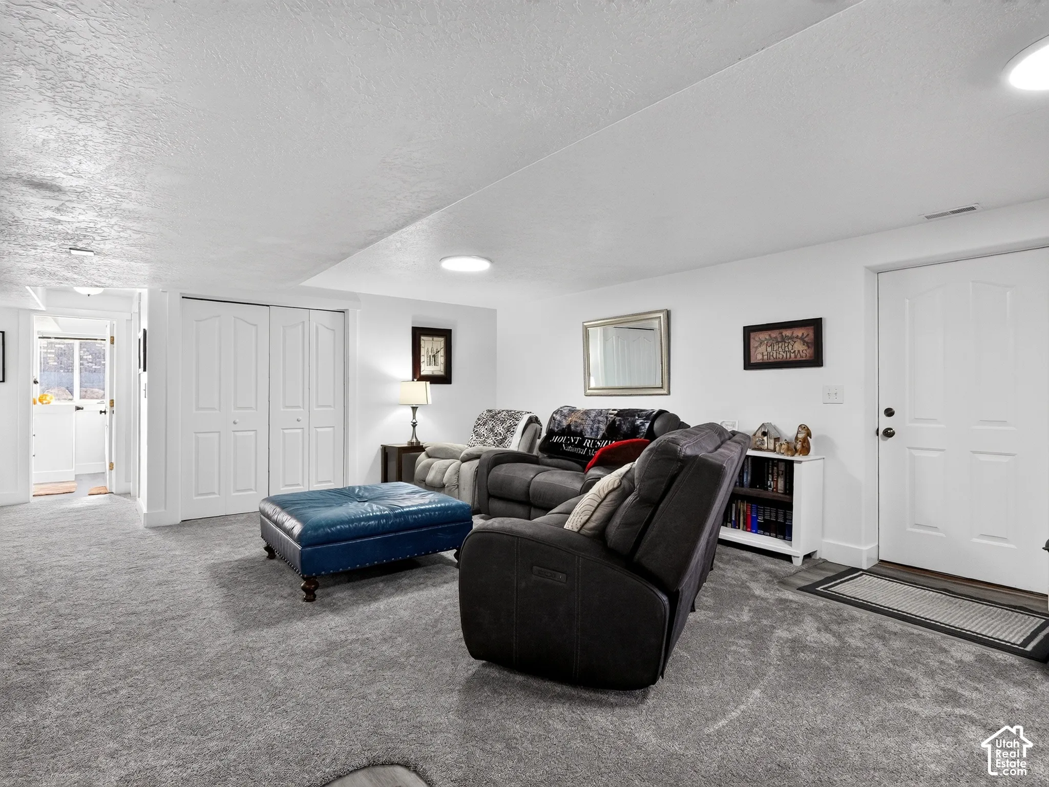 Plush carpeting, bright white walls, a built-in closet with double bifold doors, and an additional white paneled door