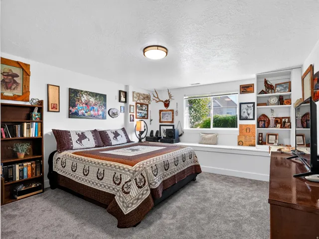 White walls, built-in shelving, a large window, a window seat, and carpeted flooring