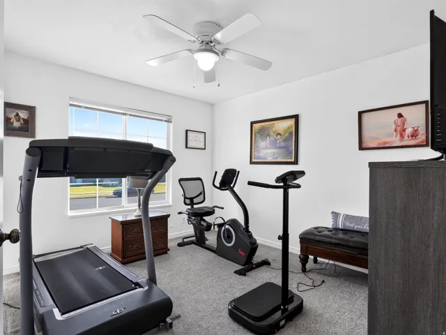 Recessed window with white trim, gray carpet flooring, white walls, and a ceiling fan with integrated lighting