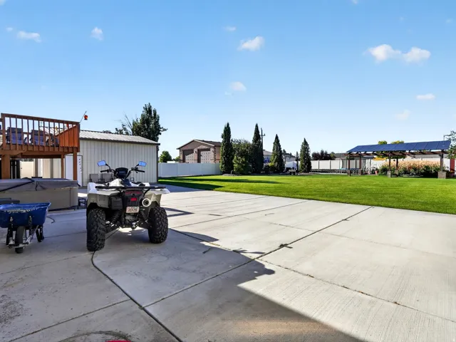 Expansive concrete patio leading to a large manicured lawn