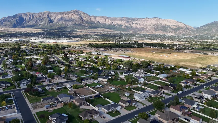 Neighborhood setting with residential properties, paved streets, and a mountainous backdrop