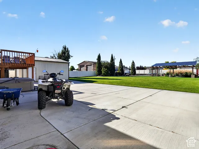 Expansive concrete patio leading to a large manicured lawn