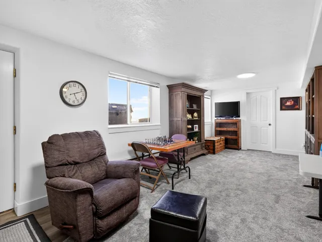 Recessed lighting, light-colored walls, window with natural light, wall-to-wall carpeting, and a built-in wall unit