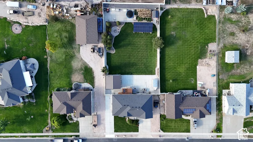 Expansive lot featuring a large grassy area, paved driveways, and multiple residential structures