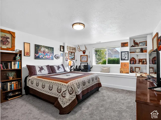 White walls, built-in shelving, a large window, a window seat, and carpeted flooring