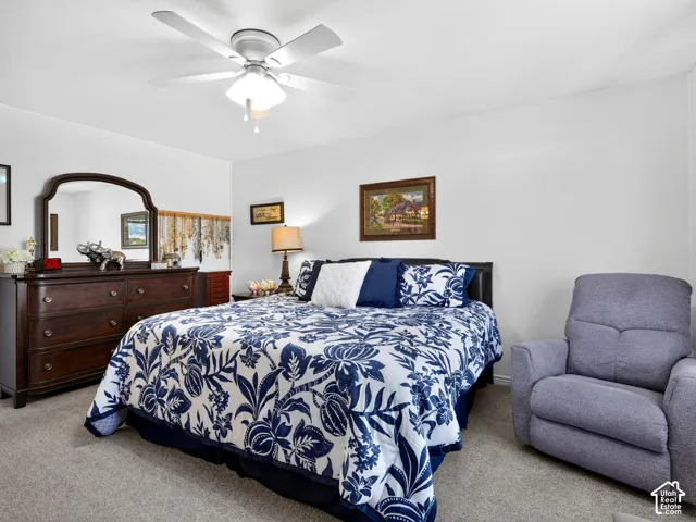 Ceiling fan with integrated lighting, neutral wall paint, and gray carpeting