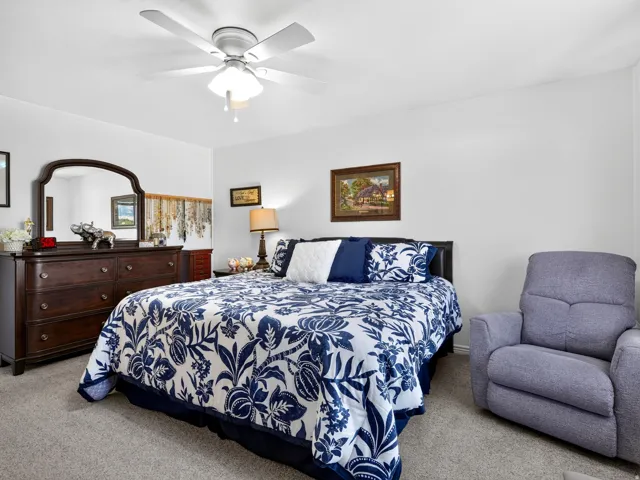 Ceiling fan with integrated lighting, neutral wall paint, and gray carpeting