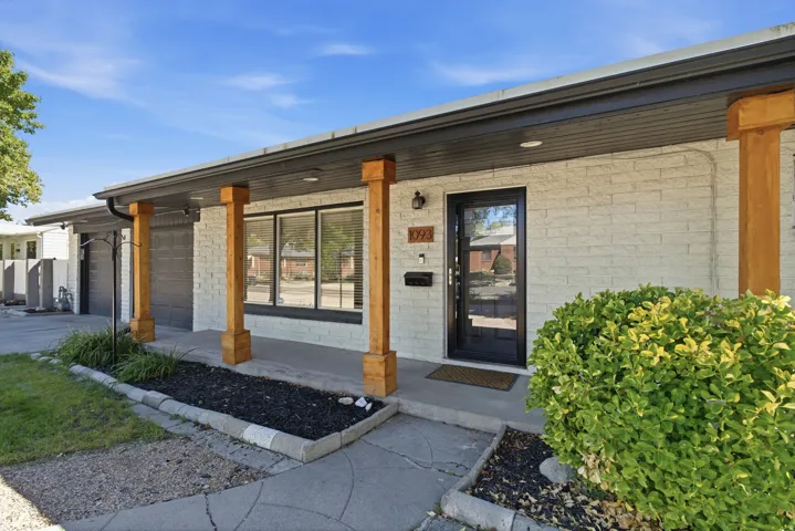 White brick exterior with prominent wood columns and dark gray trim