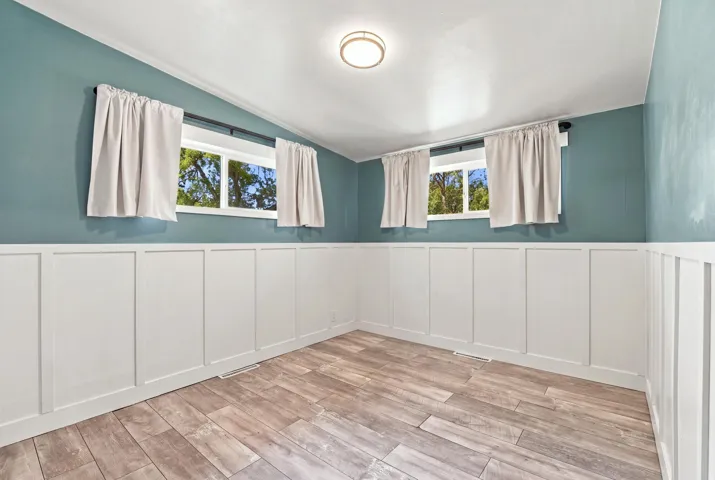 Wood-finish flooring with a white board and batten wall treatment