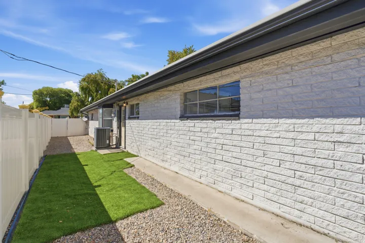 Back of the house with imitation grass over rocks. Could be removed.