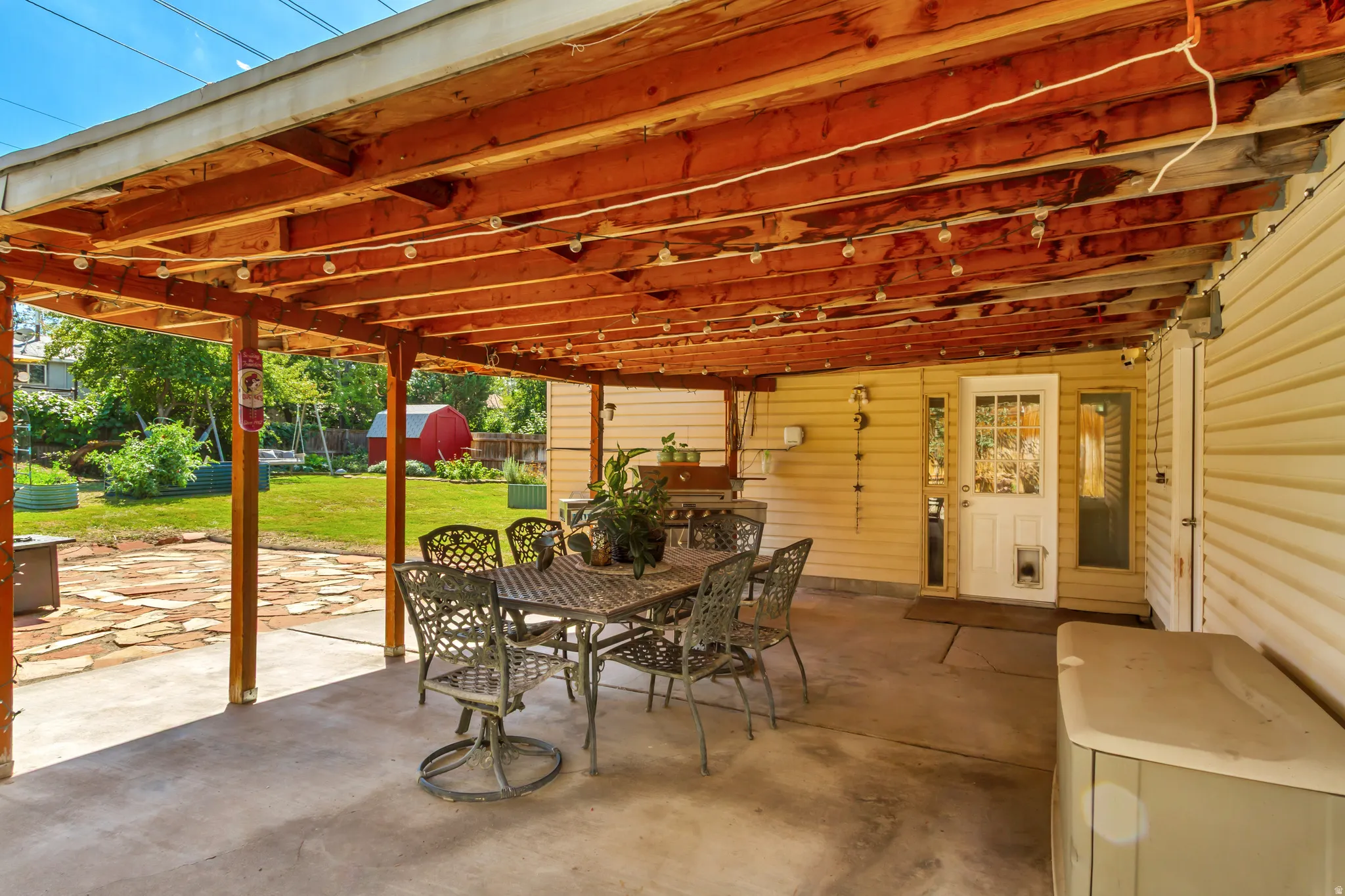 Covered patio with a concrete surface, exposed wood beam ceiling, and direct access to the interior