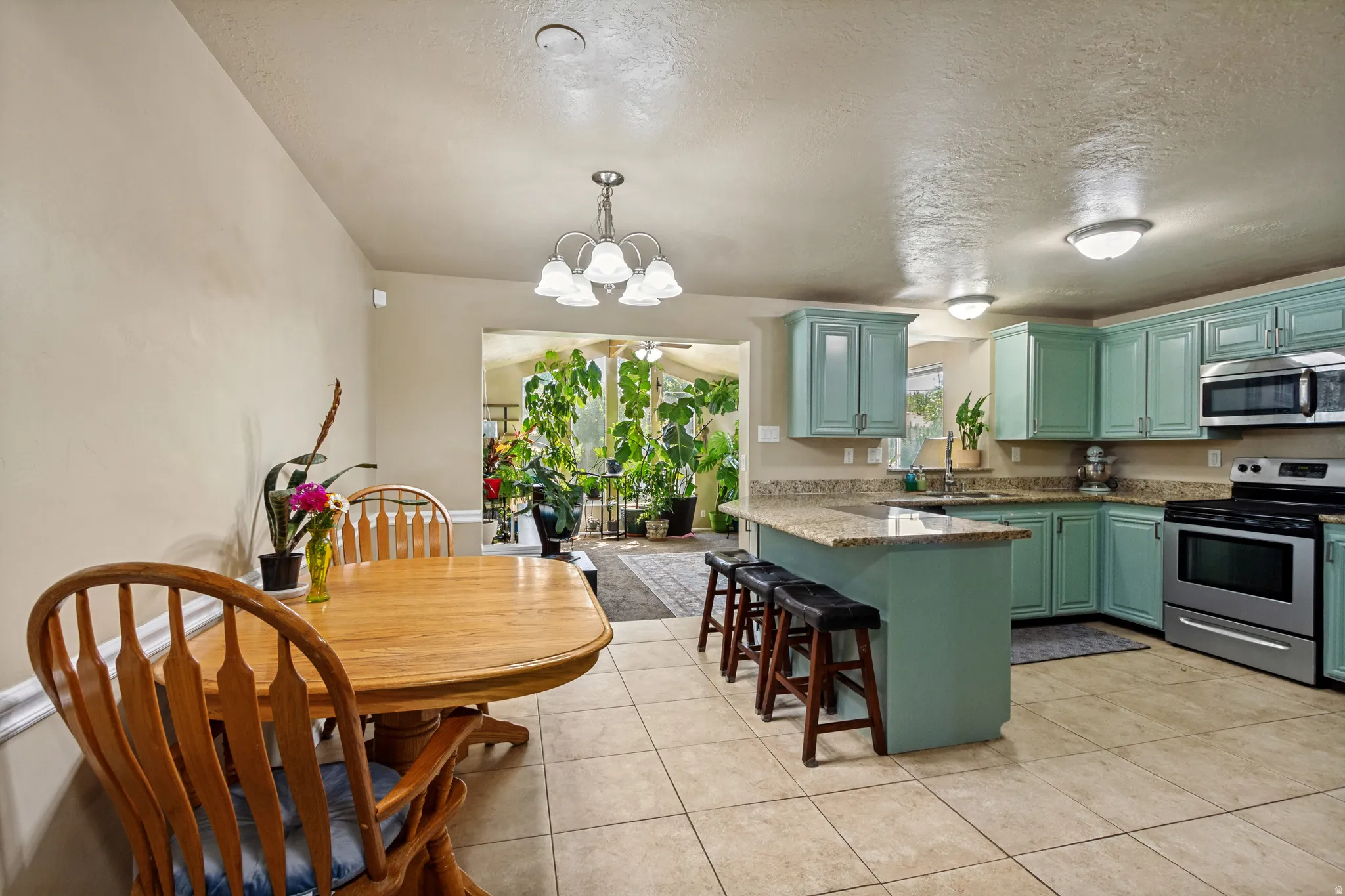 Kitchen featuring light blue cabinetry, stainless steel appliances, and a central island with a stone countertop